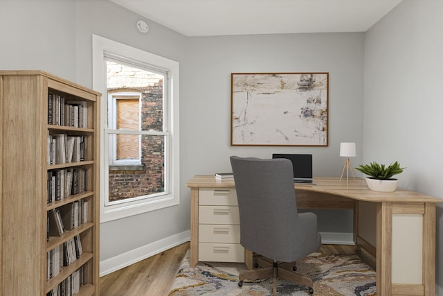 home office with light hardwood / wood-style flooring