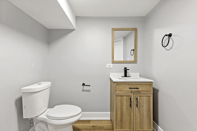 bathroom featuring toilet, wood-type flooring, and vanity