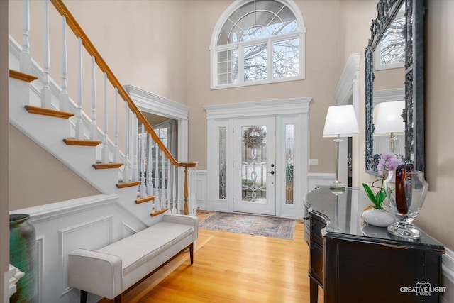 entryway featuring a wealth of natural light, light hardwood / wood-style flooring, and a high ceiling