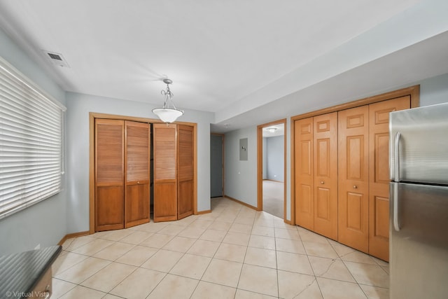 kitchen with decorative light fixtures, light tile patterned floors, and stainless steel refrigerator