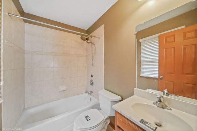 full bathroom featuring tiled shower / bath combo, toilet, and vanity