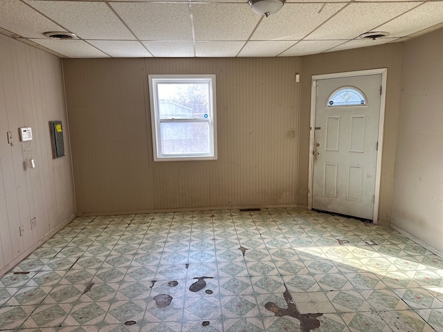 entrance foyer featuring wood walls and a drop ceiling