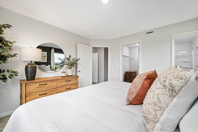 carpeted bedroom featuring a closet and a walk in closet