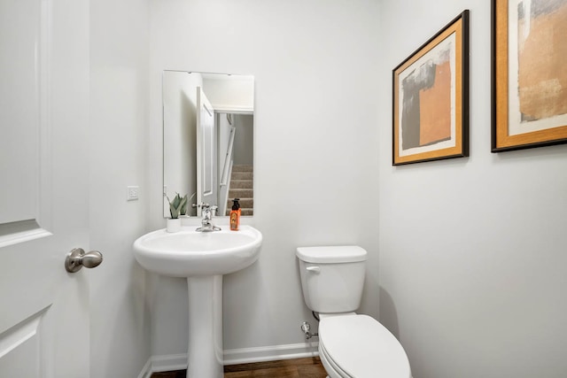 bathroom with toilet, hardwood / wood-style floors, and sink