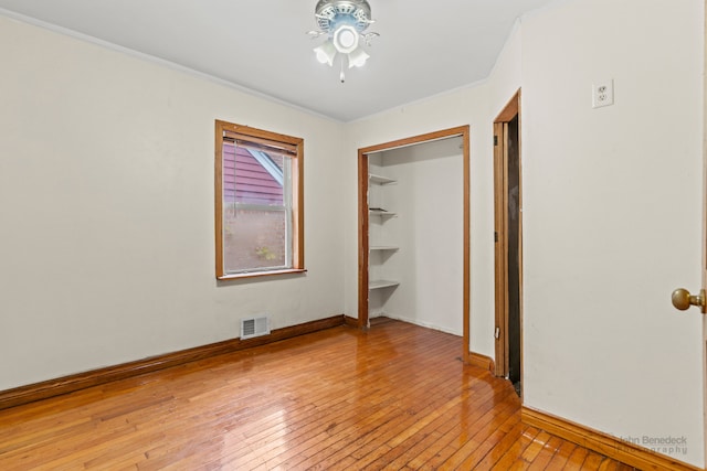 unfurnished bedroom with light wood-type flooring, a closet, and ornamental molding