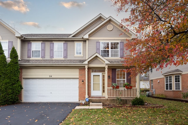 view of front of property with a front lawn, a porch, and a garage