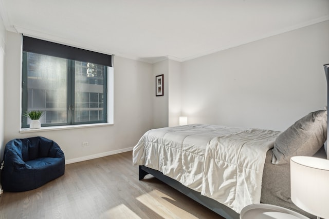 bedroom with light hardwood / wood-style flooring and ornamental molding