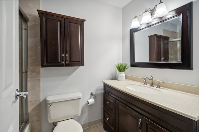 bathroom with vanity, toilet, and a shower with shower door