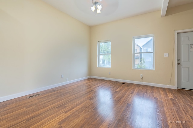 unfurnished room featuring beam ceiling, ceiling fan, and dark hardwood / wood-style flooring