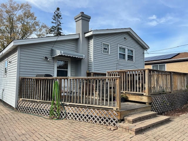 rear view of house featuring a wooden deck