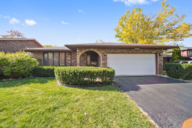 ranch-style home featuring a garage and a front lawn