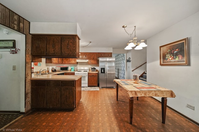 kitchen featuring an inviting chandelier, sink, appliances with stainless steel finishes, dark brown cabinets, and kitchen peninsula