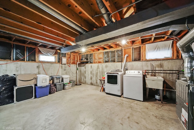 basement featuring plenty of natural light, washer and dryer, and sink