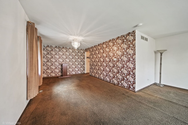 interior space featuring dark colored carpet and a notable chandelier