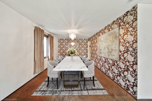 dining room with dark carpet and a chandelier