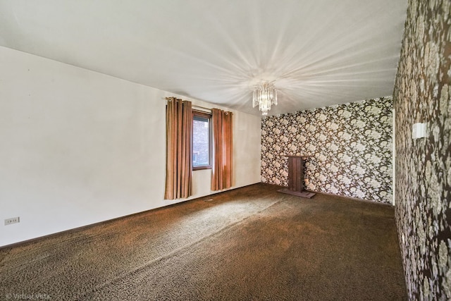 carpeted empty room with a chandelier