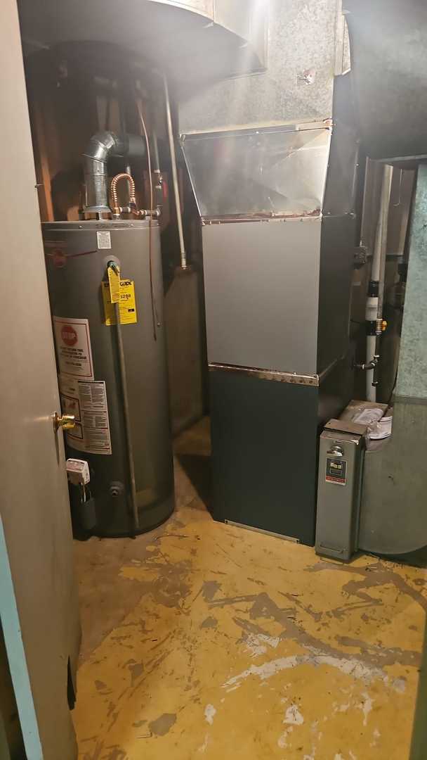 utility room with heating unit and water heater