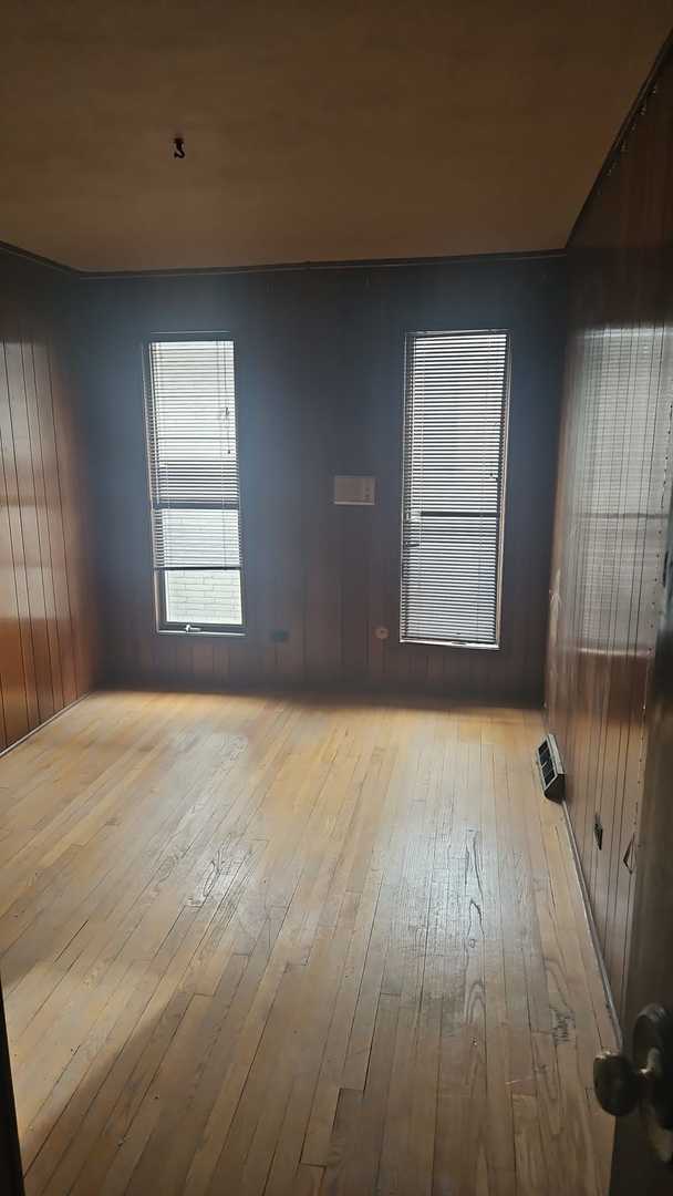 empty room with wood walls and light wood-type flooring