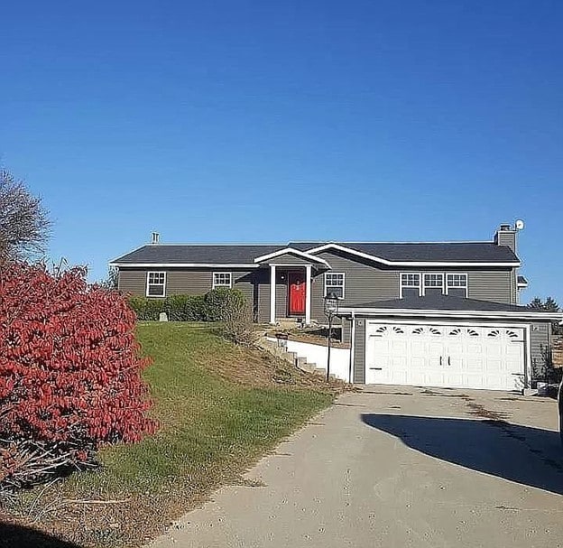 manufactured / mobile home featuring a front yard and a garage