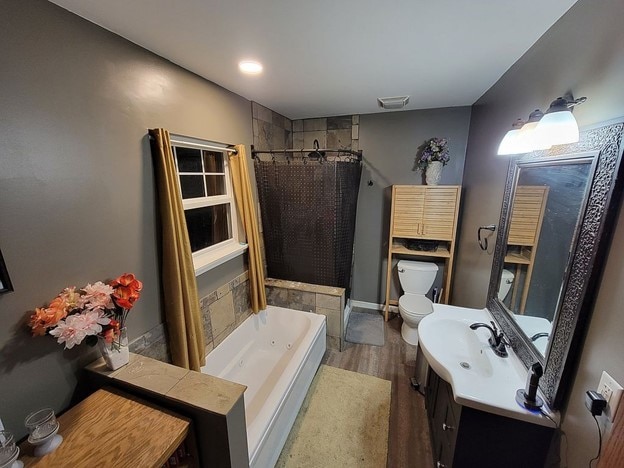 full bathroom featuring hardwood / wood-style floors, vanity, shower with separate bathtub, and toilet