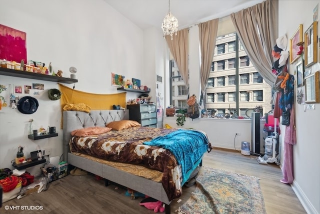 bedroom featuring an inviting chandelier and light wood-type flooring