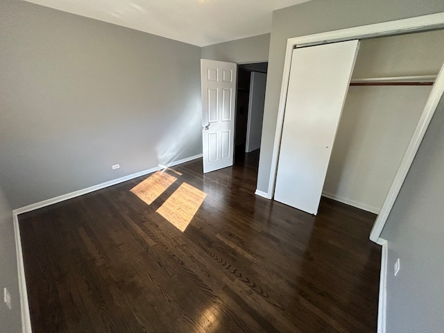 unfurnished bedroom featuring a closet and dark hardwood / wood-style floors