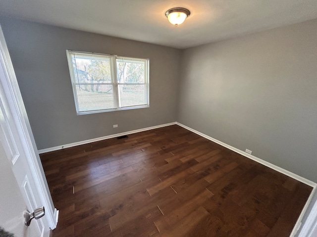 spare room with dark wood-type flooring