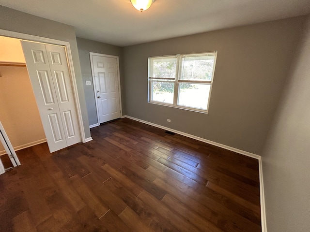 unfurnished bedroom featuring dark hardwood / wood-style flooring