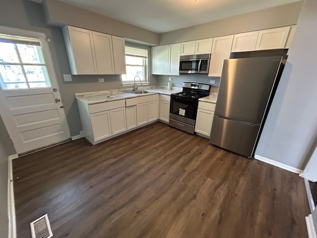 kitchen featuring white cabinetry, appliances with stainless steel finishes, and a wealth of natural light