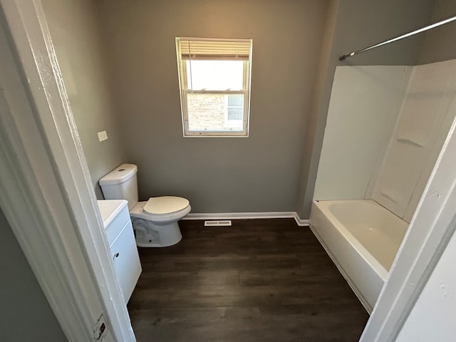 full bathroom with washtub / shower combination, wood-type flooring, vanity, and toilet