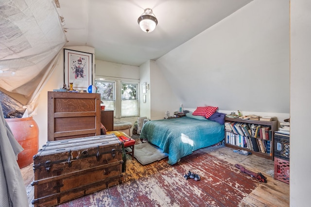 bedroom with vaulted ceiling and hardwood / wood-style flooring