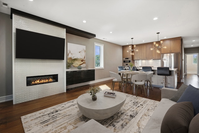 living room featuring a wealth of natural light, dark hardwood / wood-style floors, and a notable chandelier