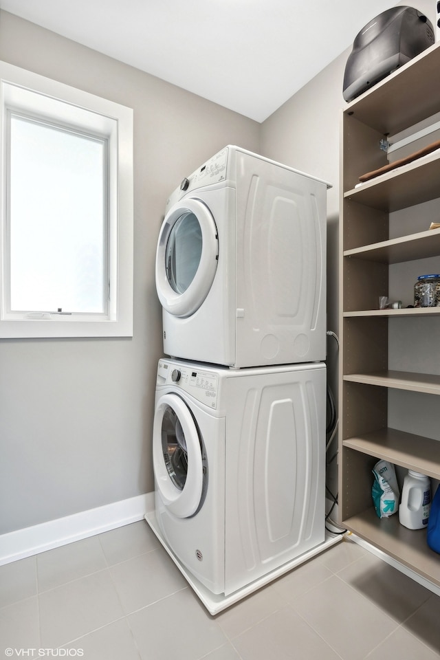 laundry room featuring light tile patterned floors and stacked washing maching and dryer