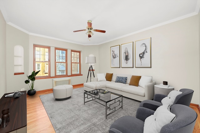 living room featuring hardwood / wood-style floors, ceiling fan, and crown molding