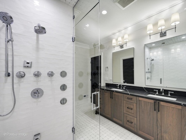 bathroom featuring double vanity, a stall shower, a sink, and visible vents