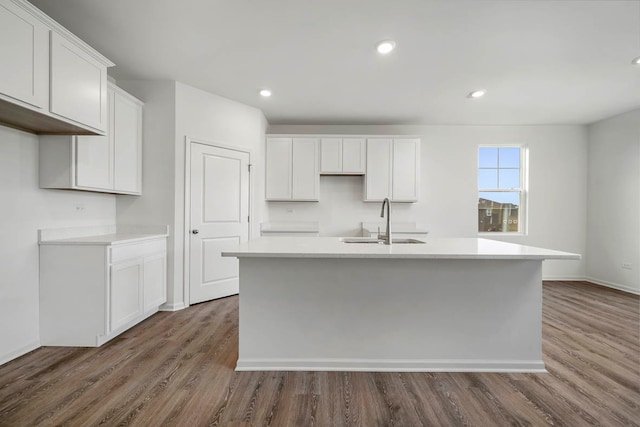 kitchen with white cabinetry, sink, a center island with sink, and wood-type flooring