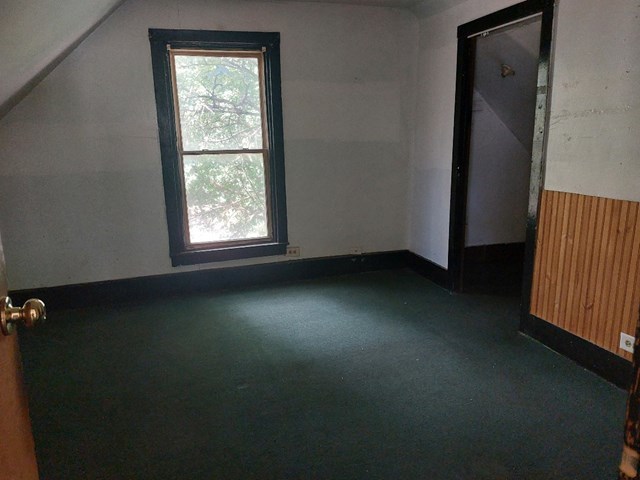 bonus room featuring dark colored carpet and lofted ceiling