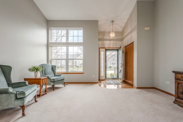 carpeted entrance foyer featuring high vaulted ceiling, a wealth of natural light, and a notable chandelier