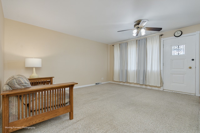 carpeted entryway featuring ceiling fan