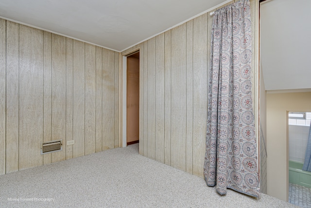 empty room featuring carpet flooring and wooden walls