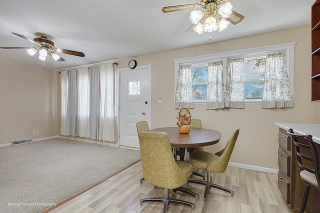 dining space with ceiling fan and light hardwood / wood-style flooring