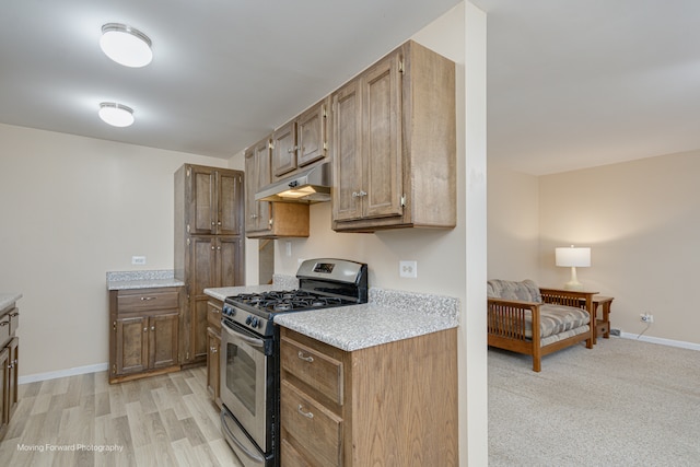 kitchen with gas stove and light hardwood / wood-style flooring