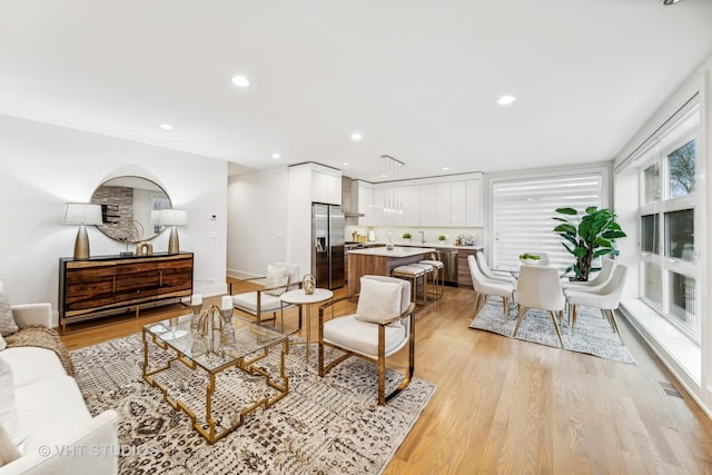 living room with a wealth of natural light and light hardwood / wood-style flooring