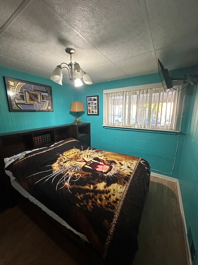 bedroom featuring multiple windows, ceiling fan with notable chandelier, and hardwood / wood-style flooring