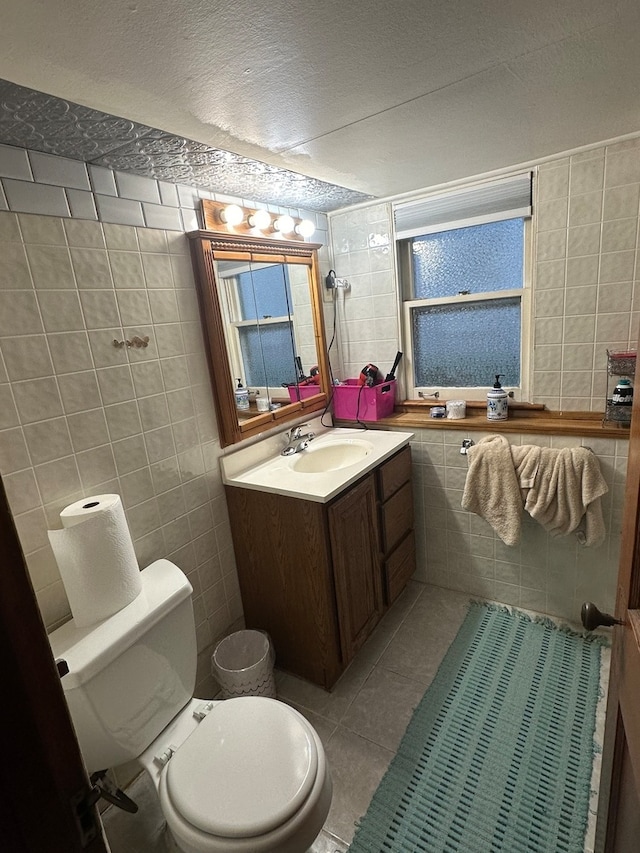 bathroom with tile patterned flooring, a textured ceiling, and tile walls