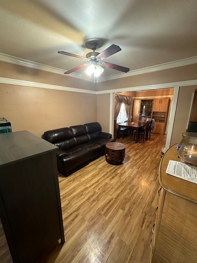 living room featuring hardwood / wood-style floors, ceiling fan, and ornamental molding