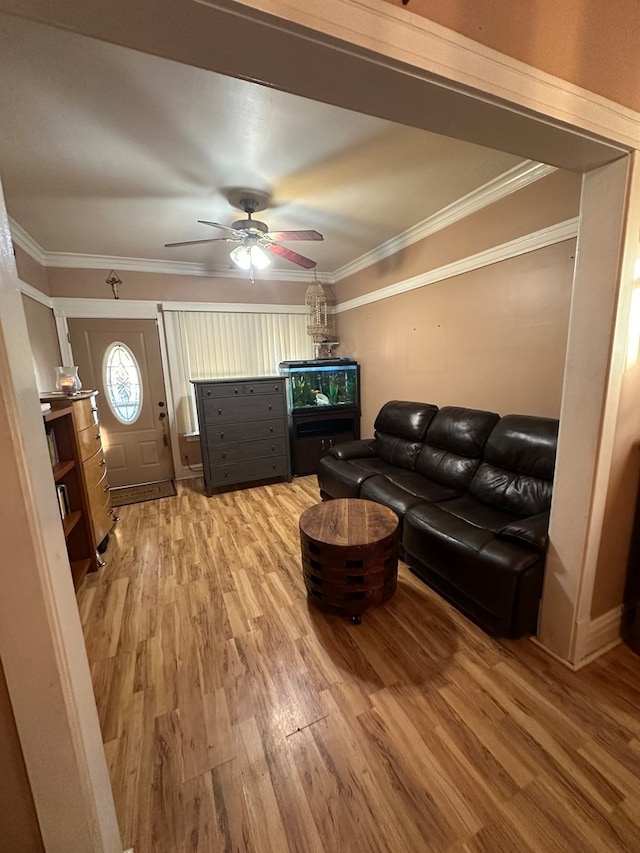 living room featuring wood-type flooring, ceiling fan, and crown molding