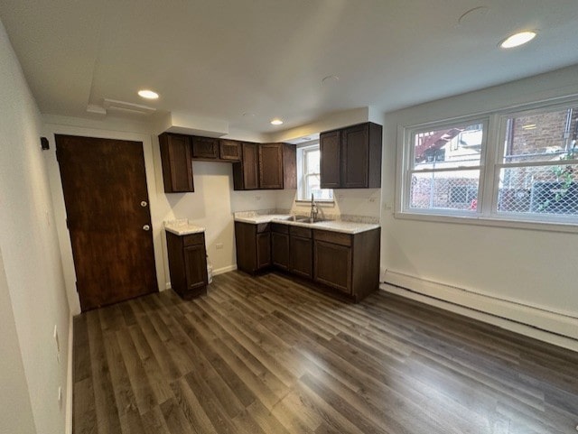 kitchen featuring baseboard heating, dark wood-type flooring, sink, and dark brown cabinets