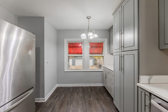 kitchen featuring gray cabinets, dark hardwood / wood-style floors, stainless steel fridge, and decorative light fixtures