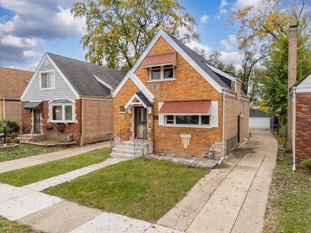 bungalow-style house with a garage, a front lawn, and an outdoor structure